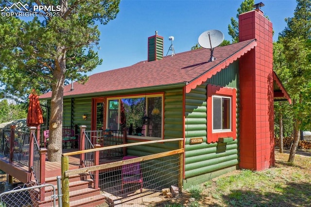 47 Red Cloud Rd, Woodland Park, CO 80863 - rear view of property with a chimney, a shingled roof, a deck, and log veneer siding