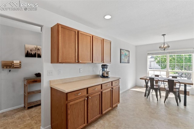6534 Harvey Ln, Colorado Springs, CO 80923 - kitchen with brown cabinetry, light countertops, decorative light fixtures, a chandelier, and recessed lighting