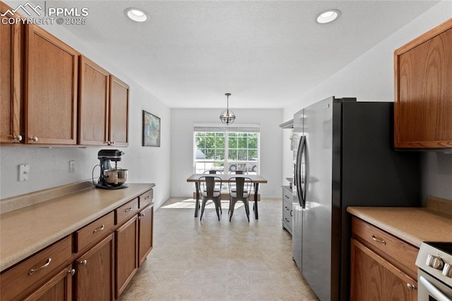 6534 Harvey Ln, Colorado Springs, CO 80923 - kitchen featuring brown cabinetry, light countertops, hanging light fixtures, range, and recessed lighting