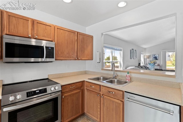 6534 Harvey Ln, Colorado Springs, CO 80923 - kitchen with stainless steel appliances, light countertops, vaulted ceiling, brown cabinets, and recessed lighting