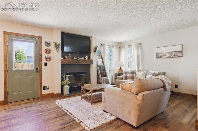 2722 Front Royal Dr, Colorado Springs, CO 80919 - living room with wood finished floors, a fireplace, and a textured ceiling