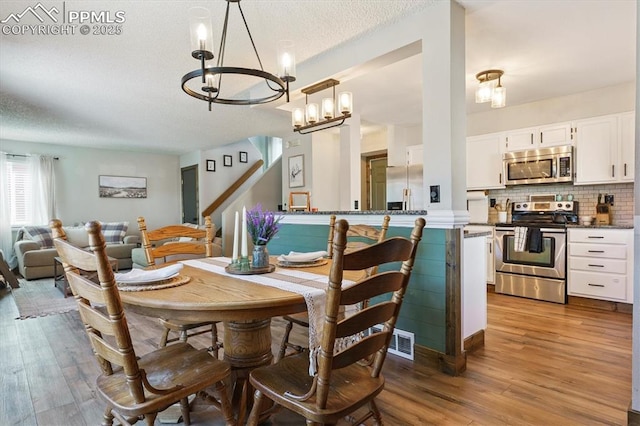 2722 Front Royal Dr, Colorado Springs, CO 80919 - dining room featuring a chandelier, hardwood / wood-style flooring, and a textured ceiling