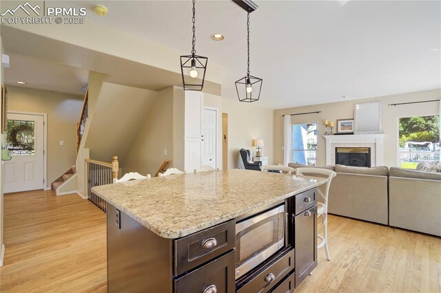 2355 Sawgrass Ct, Colorado Springs, CO 80907 - kitchen featuring stainless steel microwave, light wood-style flooring, plenty of natural light, and recessed lighting
