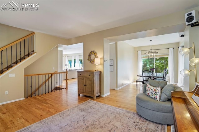 2355 Sawgrass Ct, Colorado Springs, CO 80907 - living room featuring light wood-type flooring, healthy amount of natural light, a chandelier, and stairs