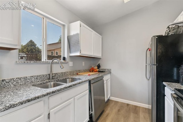 609 Wheat Field Rd, Fountain, CO 80817 - kitchen featuring stainless steel appliances, light wood-style flooring, white cabinetry, and light stone counters