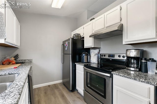 609 Wheat Field Rd, Fountain, CO 80817 - kitchen with stainless steel appliances, under cabinet range hood, light wood-style floors, and white cabinets