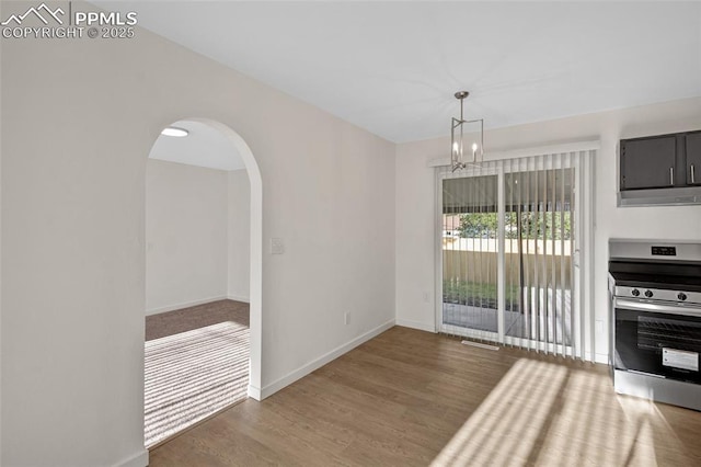 2075 Pepperwood Dr, Colorado Springs, CO 80910 - unfurnished dining area with wood finished floors, a chandelier, and arched walkways