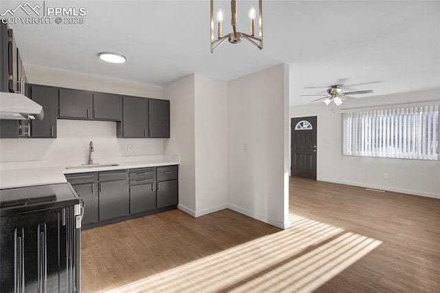 2075 Pepperwood Dr, Colorado Springs, CO 80910 - kitchen featuring electric stove, light wood-style flooring, under cabinet range hood, a chandelier, and a ceiling fan