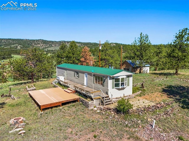 332 Valley Cir, Guffey, CO 80816 - back of property with a deck, a view of trees, and a metal roof