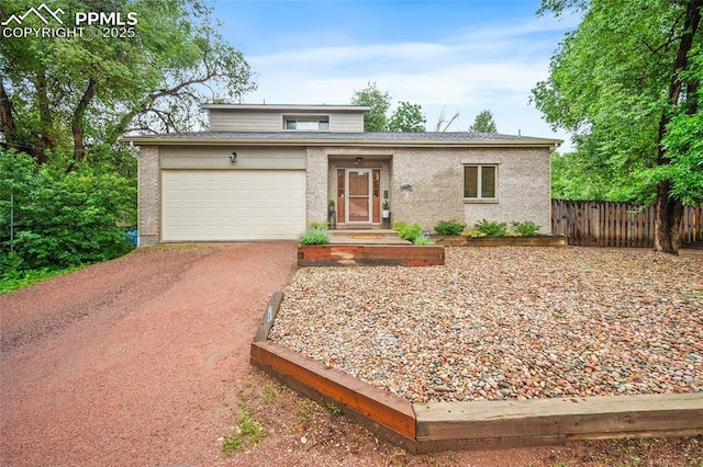 225 Laclede Ct, Colorado Springs, CO 80905 - view of front facade featuring driveway, a garage, brick siding, and roof with shingles