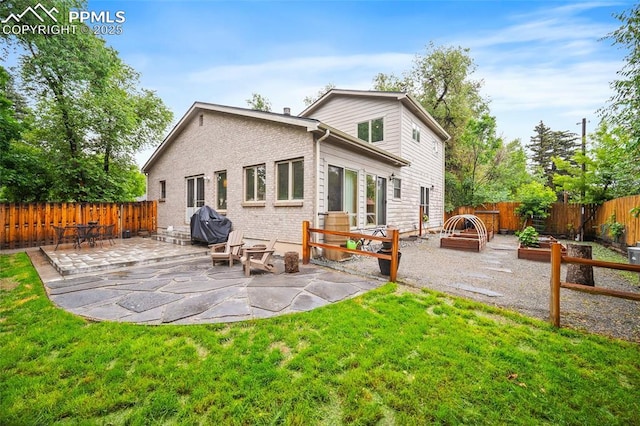 225 Laclede Ct, Colorado Springs, CO 80905 - rear view of house with a patio, a fenced backyard, brick siding, and a garden
