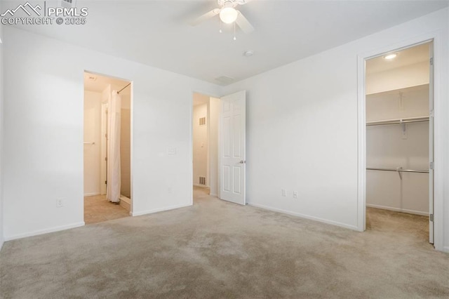 4887 Wolf Moon Dr, Colorado Springs, CO 80911 - unfurnished bedroom with a spacious closet, carpet flooring, a closet, connected bathroom, and a ceiling fan