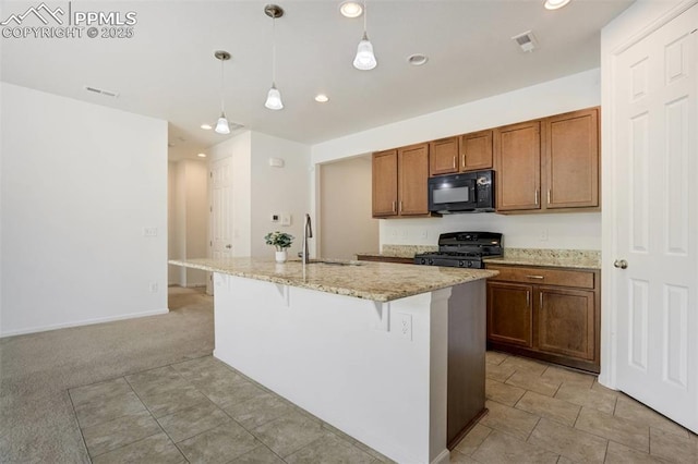 4887 Wolf Moon Dr, Colorado Springs, CO 80911 - kitchen with black microwave, range with gas cooktop, light stone countertops, a kitchen island with sink, and decorative light fixtures