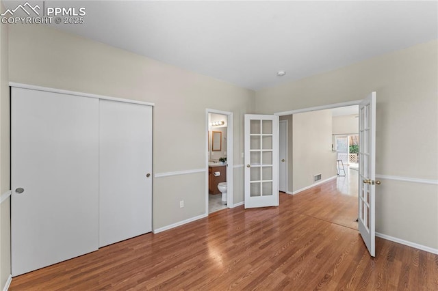 3025 Ebbtide Vw, Colorado Springs, CO 80922 - unfurnished bedroom with french doors, wood finished floors, a closet, and ensuite bath