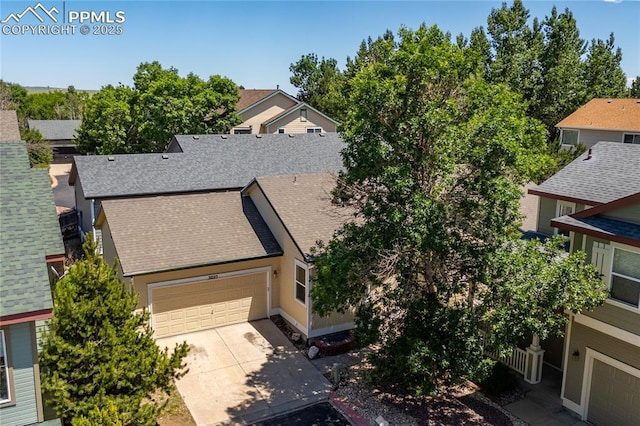 3025 Ebbtide Vw, Colorado Springs, CO 80922 - view of front of house featuring a garage, a shingled roof, concrete driveway, and a residential view