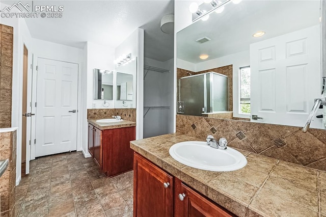 2513 Gilpin Ave, Colorado Springs, CO 80910 - full bath featuring a stall shower, two vanities, a closet, and decorative backsplash