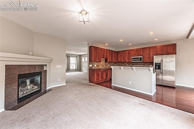 2513 Gilpin Ave, Colorado Springs, CO 80910 - kitchen with stainless steel appliances, open floor plan, a kitchen bar, dark carpet, and recessed lighting