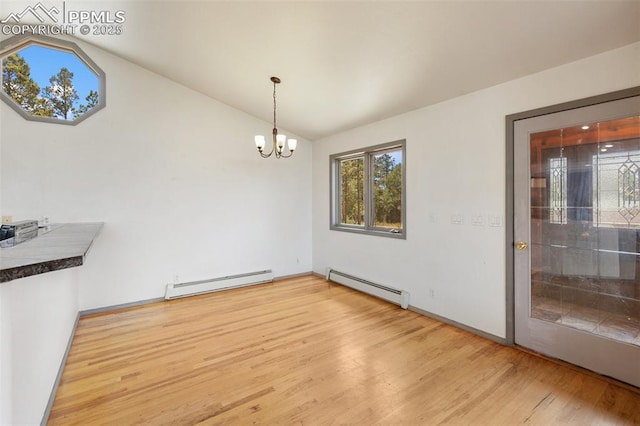 517 Drees Dr, Florissant, CO 80816 - unfurnished dining area featuring a baseboard heating unit, vaulted ceiling, wood finished floors, and a chandelier
