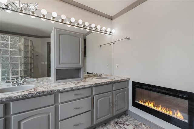 517 Drees Dr, Florissant, CO 80816 - bathroom featuring crown molding, double vanity, marble finish floors, and a glass covered fireplace