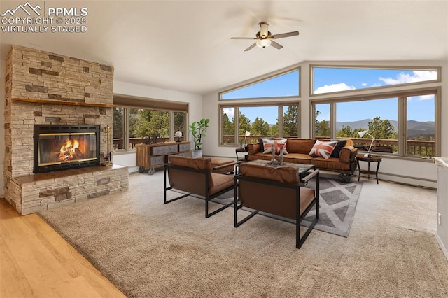 517 Drees Dr, Florissant, CO 80816 - living room featuring a baseboard radiator, a ceiling fan, lofted ceiling, a stone fireplace, and a mountain view
