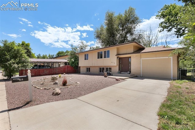 614 Bickley St, Colorado Springs, CO 80911 - tri-level home featuring a garage, concrete driveway, and brick siding