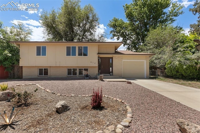614 Bickley St, Colorado Springs, CO 80911 - view of front facade with brick siding, a garage, and driveway