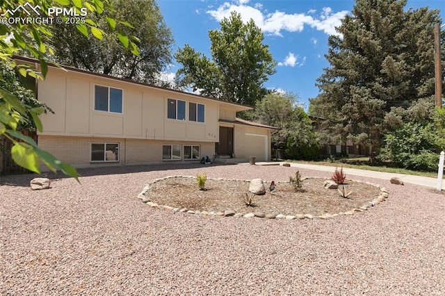 614 Bickley St, Colorado Springs, CO 80911 - view of front of home featuring a garage, board and batten siding, and brick siding