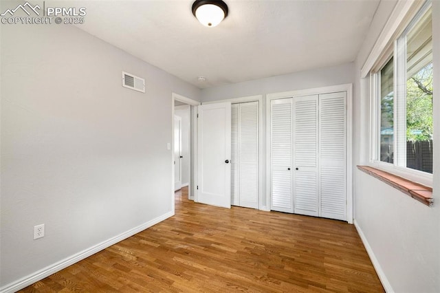 1406 N Foote Ave, Colorado Springs, CO 80909 - unfurnished bedroom featuring two closets and wood finished floors