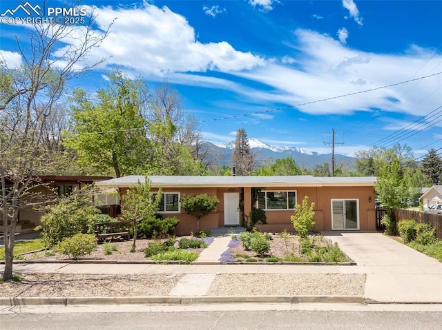 1406 N Foote Ave, Colorado Springs, CO 80909 - ranch-style house featuring a mountain view, concrete driveway, and stucco siding