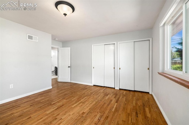 1406 N Foote Ave, Colorado Springs, CO 80909 - unfurnished bedroom featuring multiple closets and wood finished floors