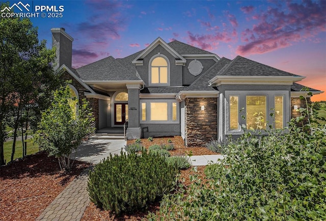 19170 Lochmere Ct, Monument, CO 80132 - view of front of house with french doors, roof with shingles, stone siding, and a chimney
