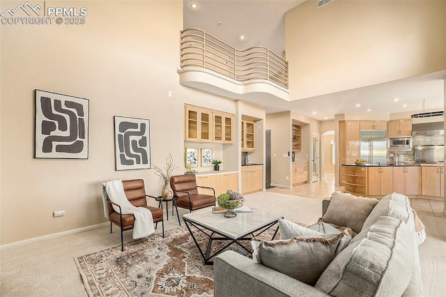 19170 Lochmere Ct, Monument, CO 80132 - living area featuring a high ceiling, recessed lighting, light colored carpet, and arched walkways