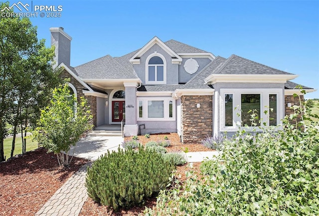 19170 Lochmere Ct, Monument, CO 80132 - view of front of house with stone siding, roof with shingles, stucco siding, and a chimney