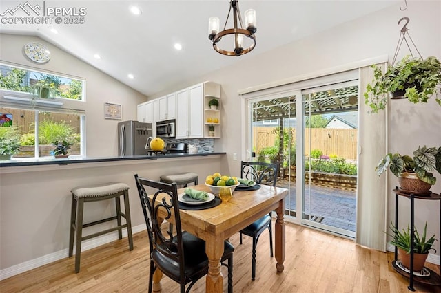 3470 Whimbrel Ln, Colorado Springs, CO 80906 - dining space featuring a chandelier, light wood-style floors, lofted ceiling, healthy amount of natural light, and recessed lighting