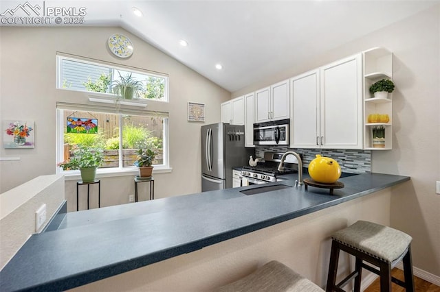 3470 Whimbrel Ln, Colorado Springs, CO 80906 - kitchen featuring appliances with stainless steel finishes, backsplash, open shelves, white cabinetry, and high vaulted ceiling