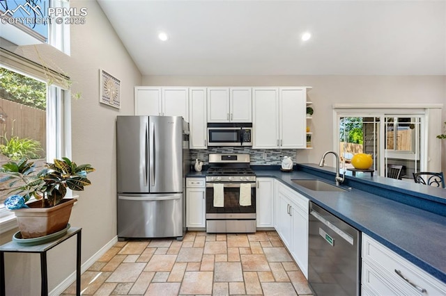 3470 Whimbrel Ln, Colorado Springs, CO 80906 - kitchen featuring appliances with stainless steel finishes, dark countertops, light stone finish floors, open shelves, and decorative backsplash