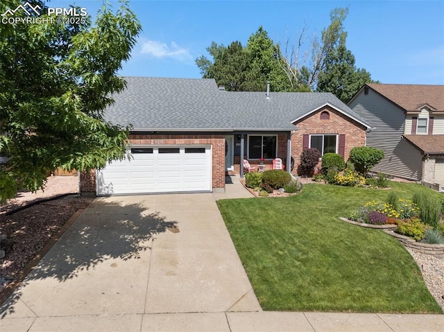 3470 Whimbrel Ln, Colorado Springs, CO 80906 - view of front of house with brick siding, concrete driveway, a garage, roof with shingles, and a front lawn