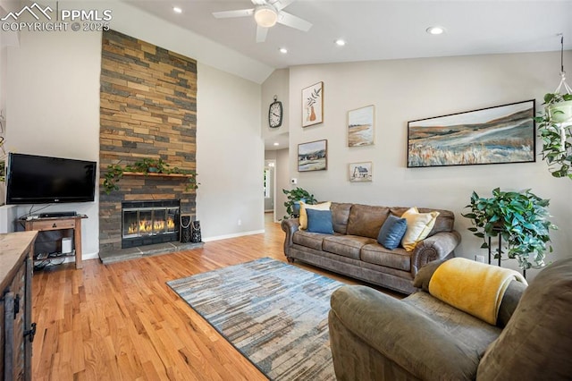 3470 Whimbrel Ln, Colorado Springs, CO 80906 - living room featuring a ceiling fan, light wood-type flooring, a stone fireplace, recessed lighting, and high vaulted ceiling
