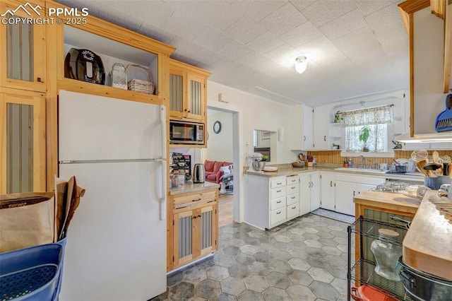 414 Griffin Ave, Canon City, CO 81212 - kitchen featuring freestanding refrigerator, stainless steel microwave, light countertops, open shelves, and white cabinetry