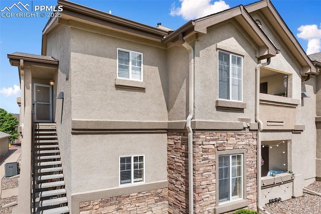 7104 Ash Creek Hts Unit 203, Colorado Springs, CO 80922 - rear view of property featuring stone siding, stucco siding, and stairway