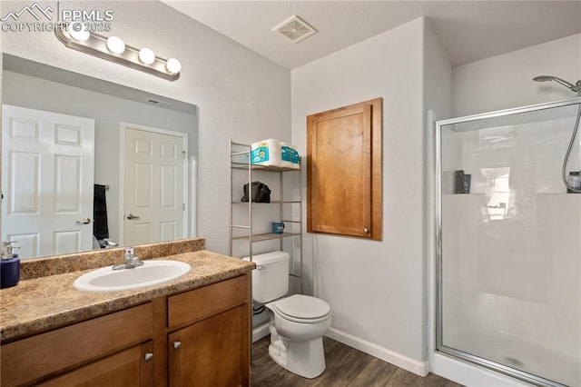 7104 Ash Creek Hts Unit 203, Colorado Springs, CO 80922 - bathroom featuring a stall shower, wood finished floors, and vanity