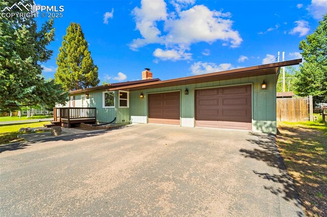 811 N Baldwin St, Woodland Park, CO 80863 - view of front of home featuring driveway, a chimney, and an attached garage