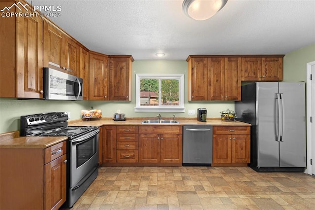 811 N Baldwin St, Woodland Park, CO 80863 - kitchen with stainless steel appliances, brown cabinets, stone finish flooring, light countertops, and a textured ceiling