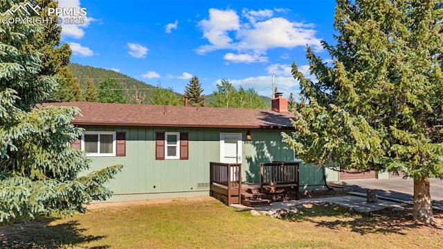 811 N Baldwin St, Woodland Park, CO 80863 - rear view of property featuring a lawn, a chimney, a deck, and a shingled roof