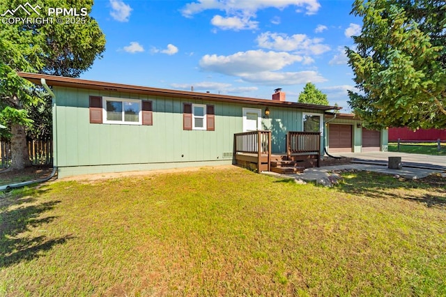 811 N Baldwin St, Woodland Park, CO 80863 - back of property with a garage, a chimney, a wooden deck, and concrete driveway