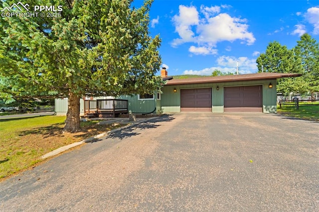 811 N Baldwin St, Woodland Park, CO 80863 - view of front of home with driveway, a garage, and a chimney