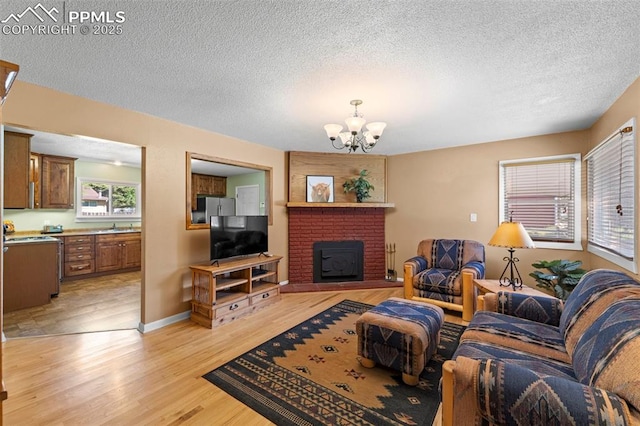 811 N Baldwin St, Woodland Park, CO 80863 - living area featuring a chandelier, light wood finished floors, a textured ceiling, and a brick fireplace