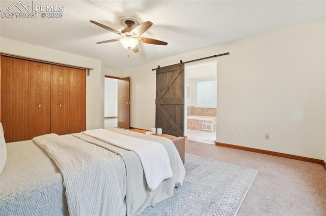 4903 Wainwright Dr, Colorado Springs, CO 80911 - carpeted bedroom featuring a barn door, a closet, ensuite bathroom, and ceiling fan