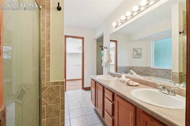 4903 Wainwright Dr, Colorado Springs, CO 80911 - full bath featuring double vanity, a garden tub, tile patterned flooring, and a stall shower