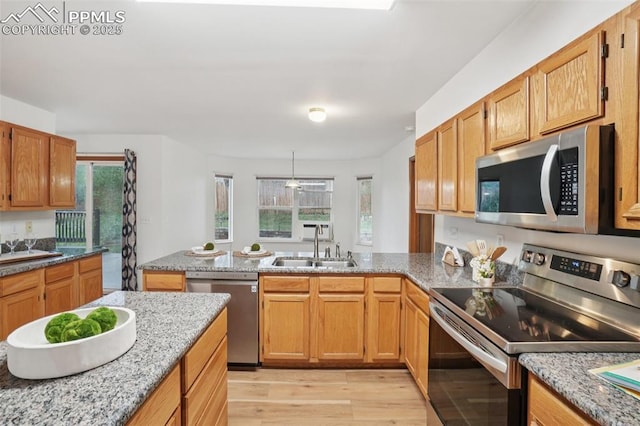 4903 Wainwright Dr, Colorado Springs, CO 80911 - kitchen with stainless steel appliances, a peninsula, light wood finished floors, pendant lighting, and light stone counters